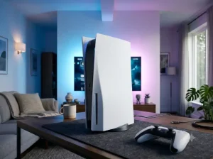 Een witte PlayStation 5-console op een bureaumat met een DualSense-controller op de voorgrond en sfeervolle gaming-verlichting.